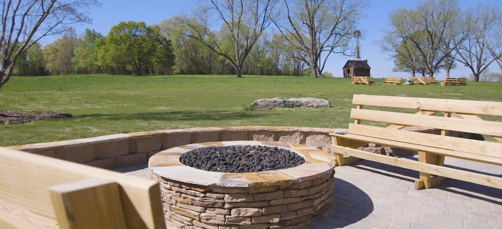 a stone fire pit surrounded by wooden benches