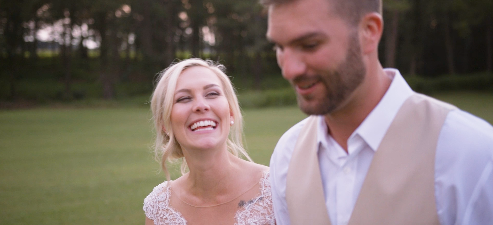 Brooke and Hugh walk through a field after their beautiful Farmville, NC wedding.