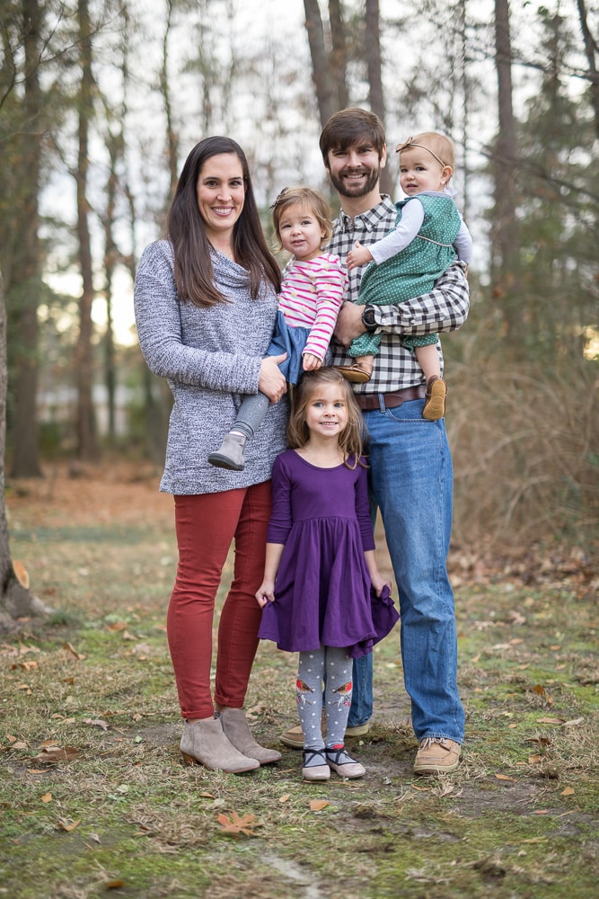 a family takes a picture in a wooded clearing