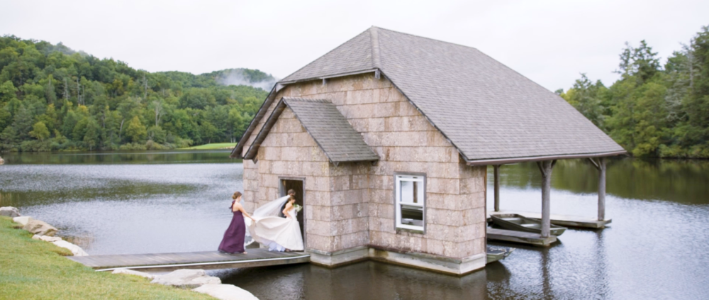 bride and groom walk into boat house