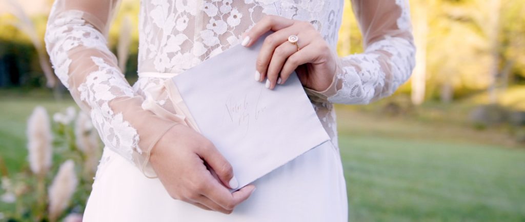 bride stands with letter from her groom