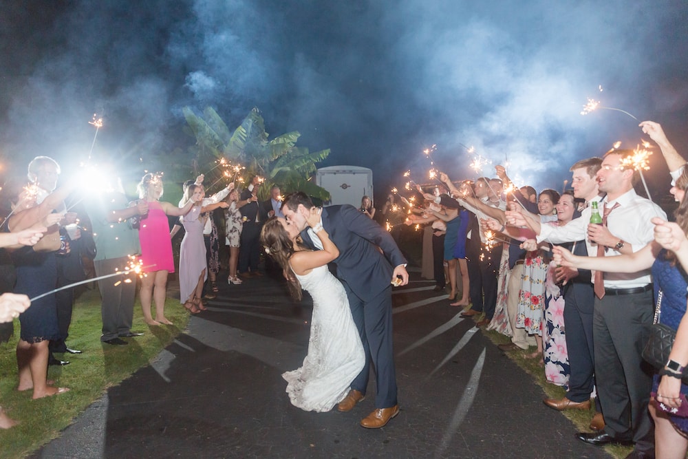 bride and groom kiss in the middle of a sparkler exit
