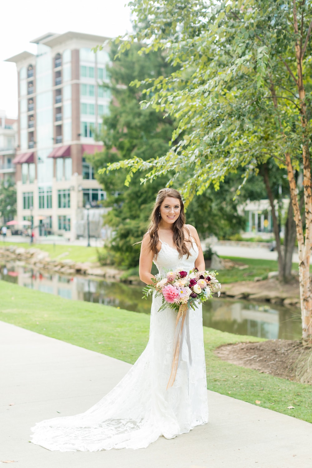 bride stands on a sidewalk in a city
